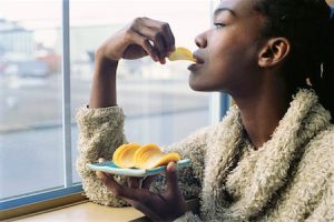A black woman eating potato